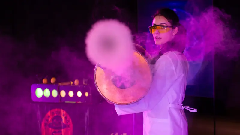 Eine Wissenschaftlerin feuert einen Rauchring aus einer Trommel ab